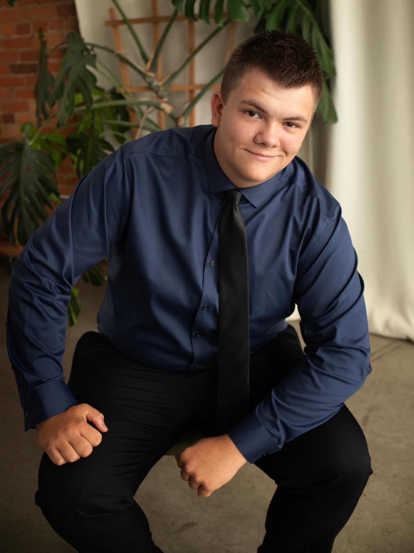 Senior in a navy shirt and tie in a studio portrait