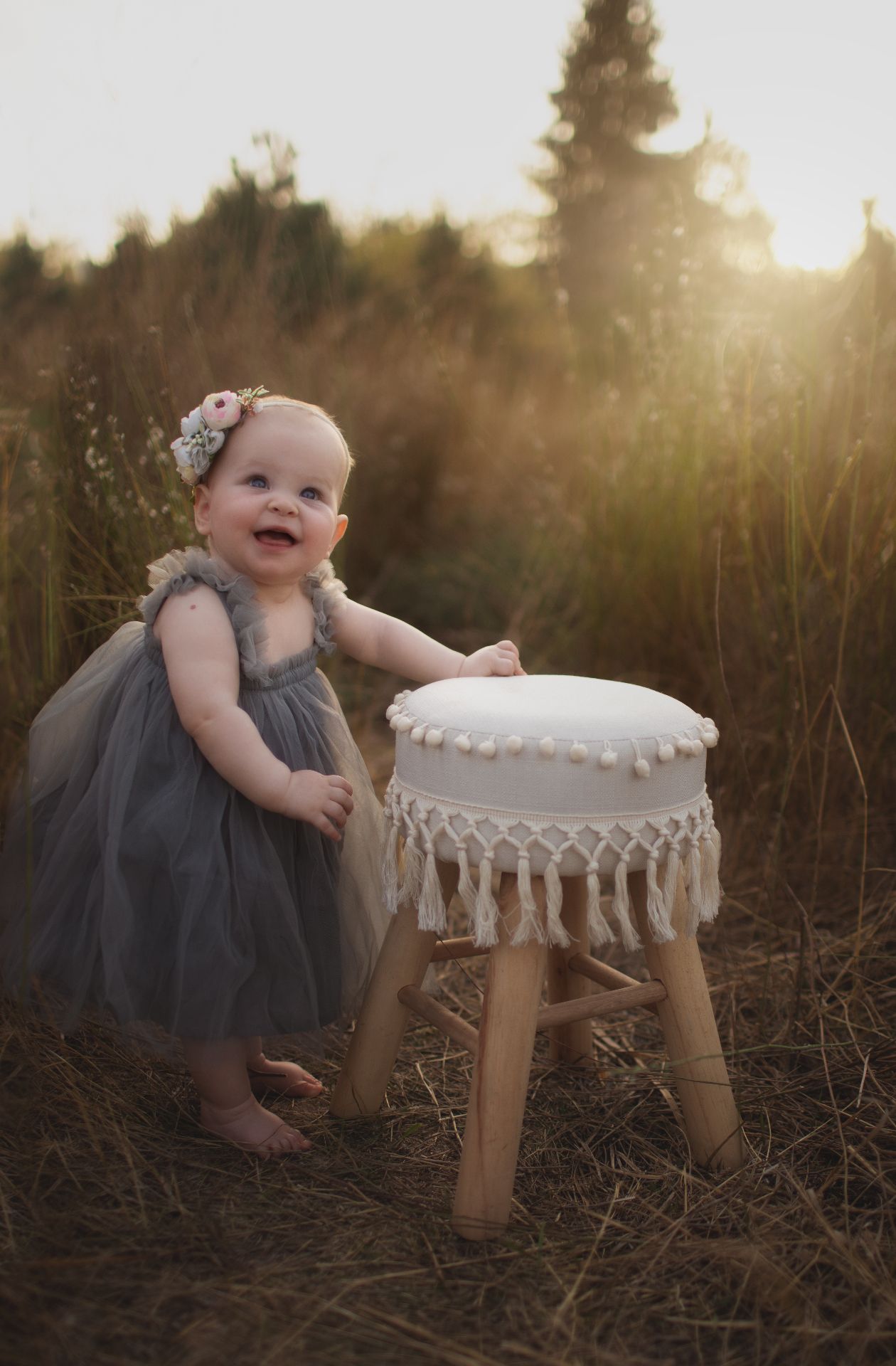 Baby seated on a wooden stool