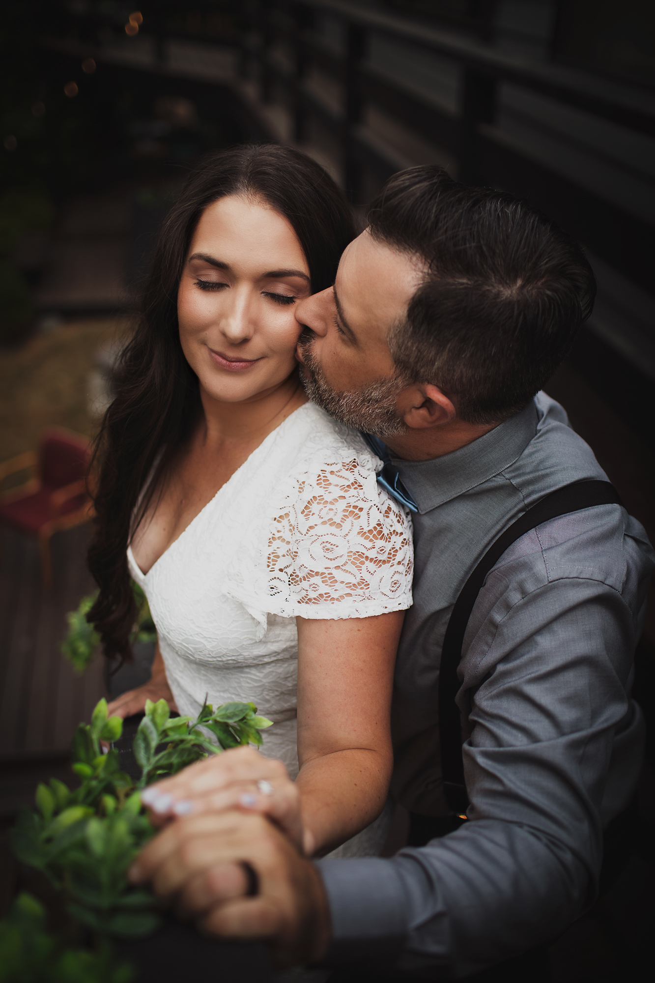 Groom kissing the bride's cheek in low evening light